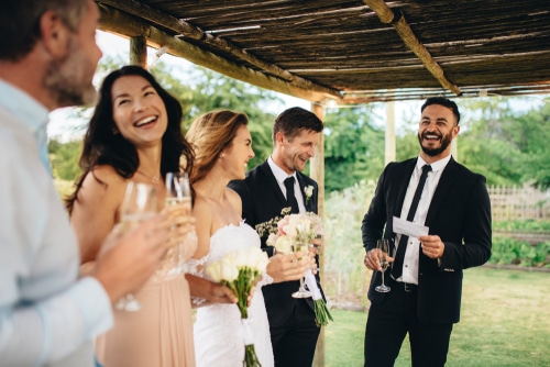 Best man giving a speech to newlyweds at wedding
