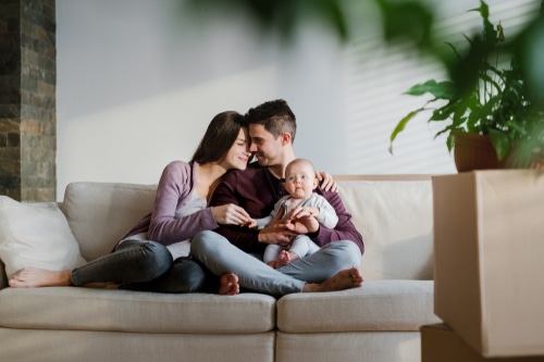 A Portrait Of Young Couple With A Baby And Cardboard
