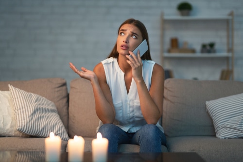 Woman on phone frustrated by power outage