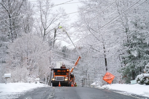 Lineman working on powerlines on a snowy road