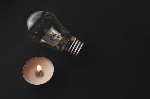 Electric Lamp And Candle On A Dark Background.