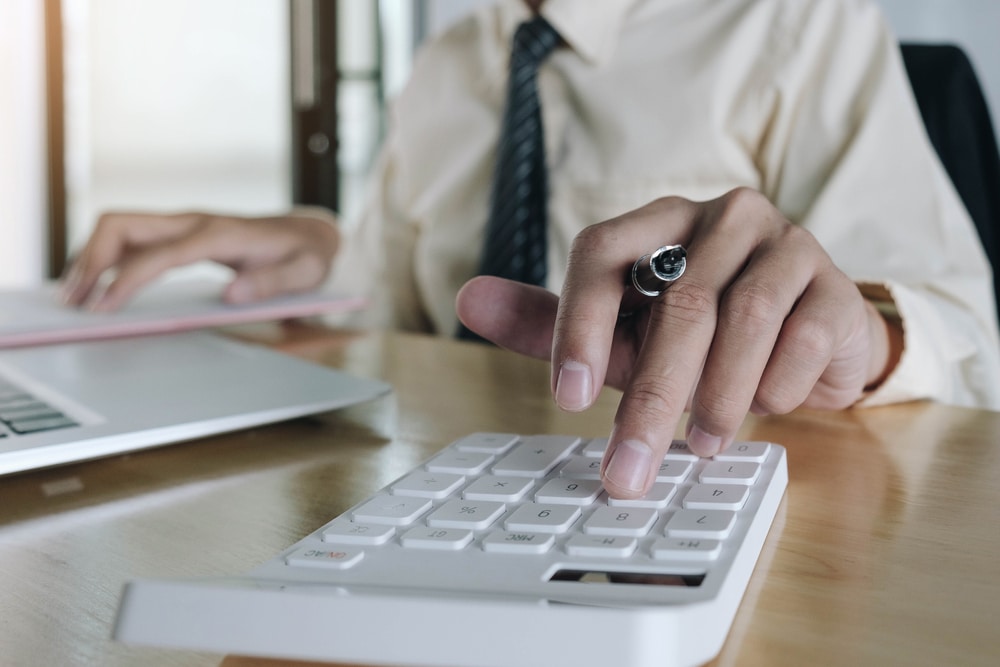 Close Up Business Woman Using Calculator And Laptop