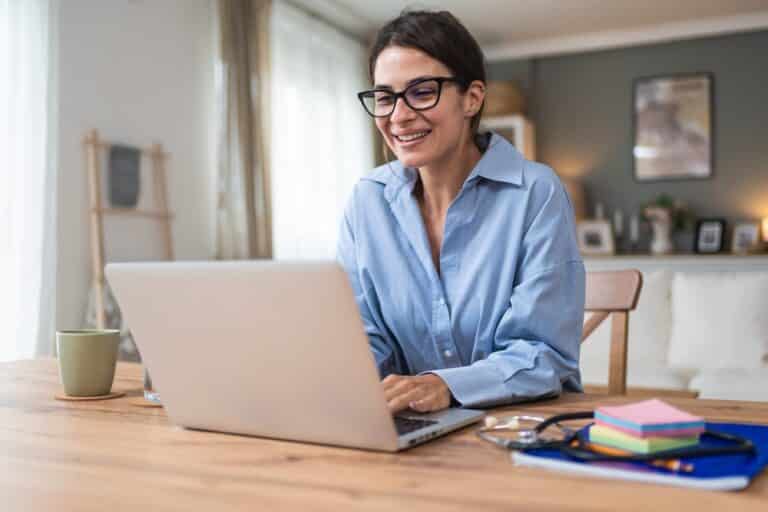 Woman working from home looking at her laptop